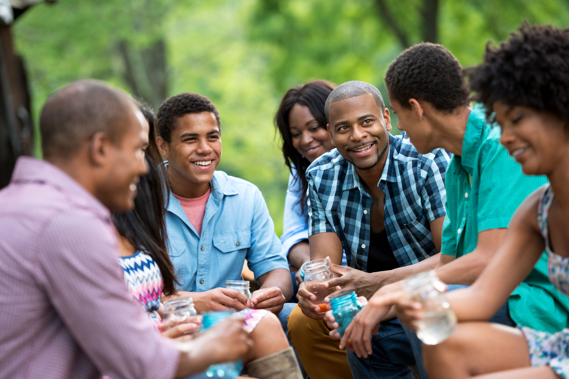 Black adults gathered outside, smiling and connecting, representing building community as a Black adult through shared social time.