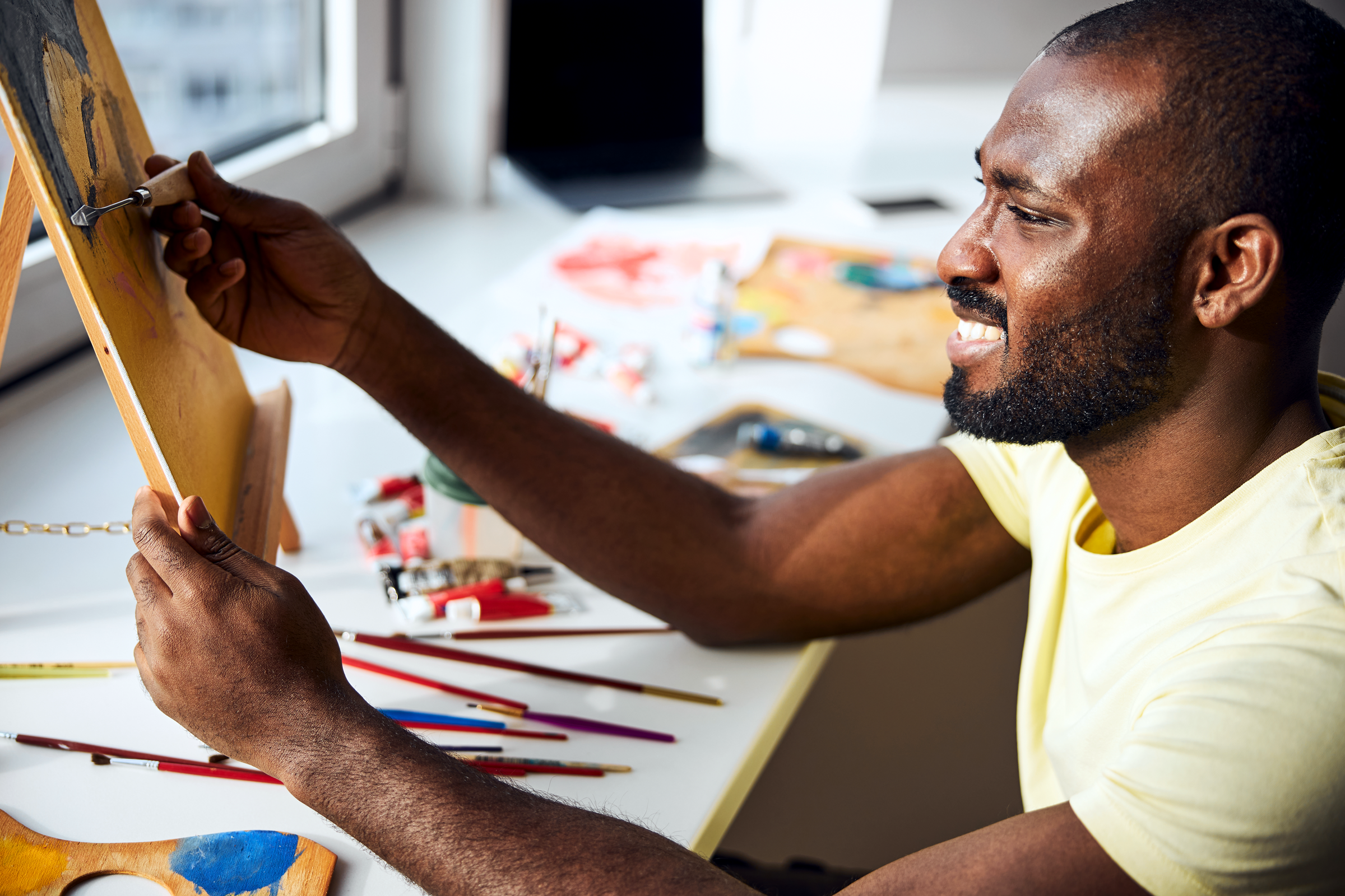 Black man painting as a form of reflection and self-expression supporting Black men’s mental health in Alameda County